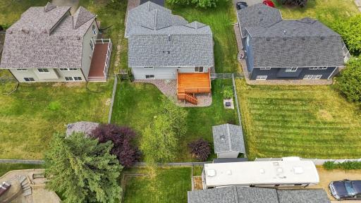 Bird's-eye view showcases the fully fenced yard, deck, storage shed, and impressive outdoor space.