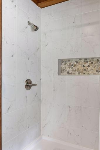 Walk-in tiled shower adjacent to lower bedroom