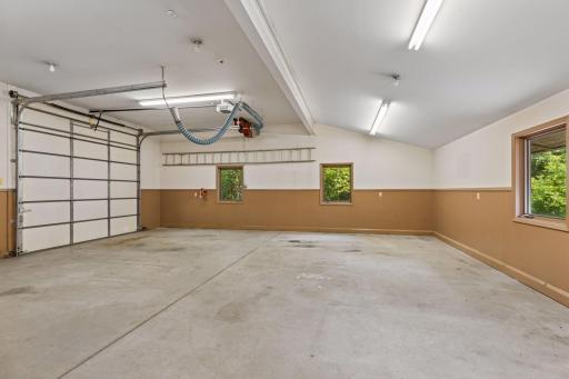Separate garage or workshop measuring 26 feet x 38 feet with an outside service door and an RV-sized overhead garage door measuring 10' 3" x 10' 3". On the ceiling is a vehicle exhaust ventilation system. In-floor geothermal heating