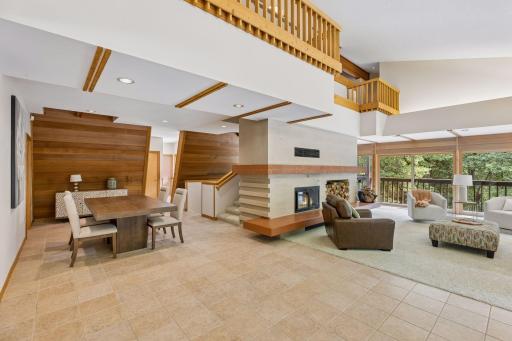 Dining room with tiled floor and redwood-lined angled wall. The living room has an 18-foot open ceiling that is angled