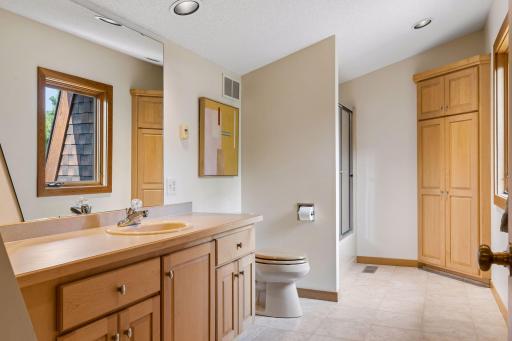 Upper-level full bathroom with tiled floor and maple cabinetry