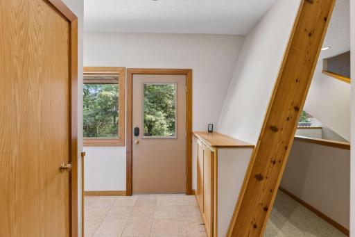 Back entry to mudroom with tiled floor and 1/2 bathroom, and laundry room