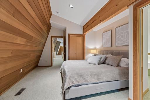 Upper-level bedroom with architectural redwood wall and walk-in closet