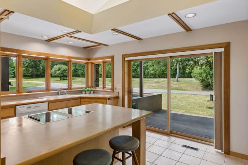 Kitchen with ample windows and a sliding glass door to a small concrete patio