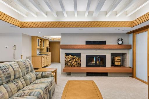 Lower-level family room with recessed lighting and wood fireplace. In-floor geothermal heating