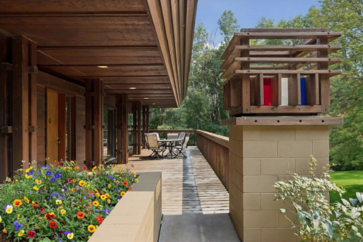 Planter flower box at the front entrance to add a pop of color leading to the large deck with a roof overhang for shade.
