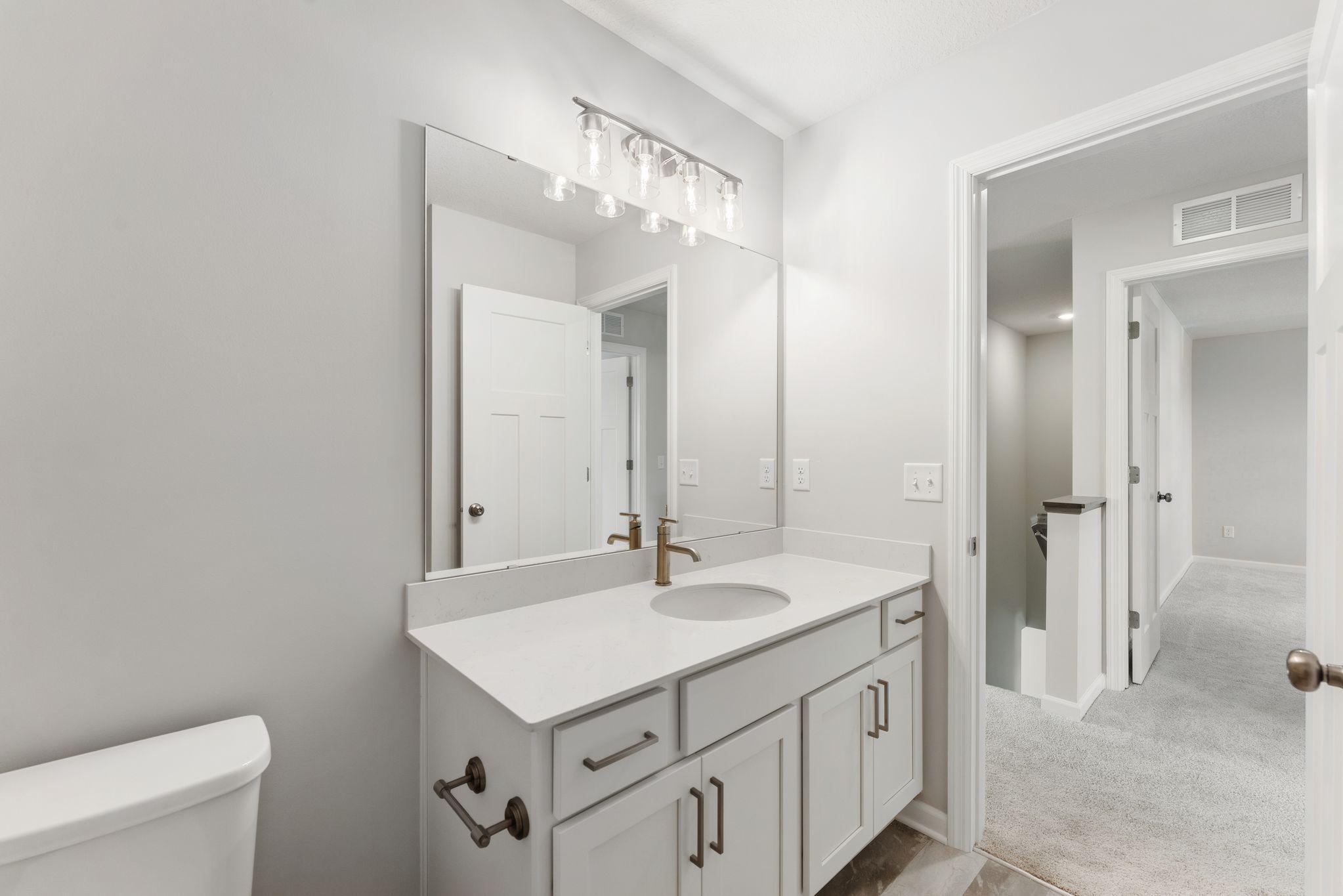 Another bathroom upstairs has quartz counters and modern finishes.