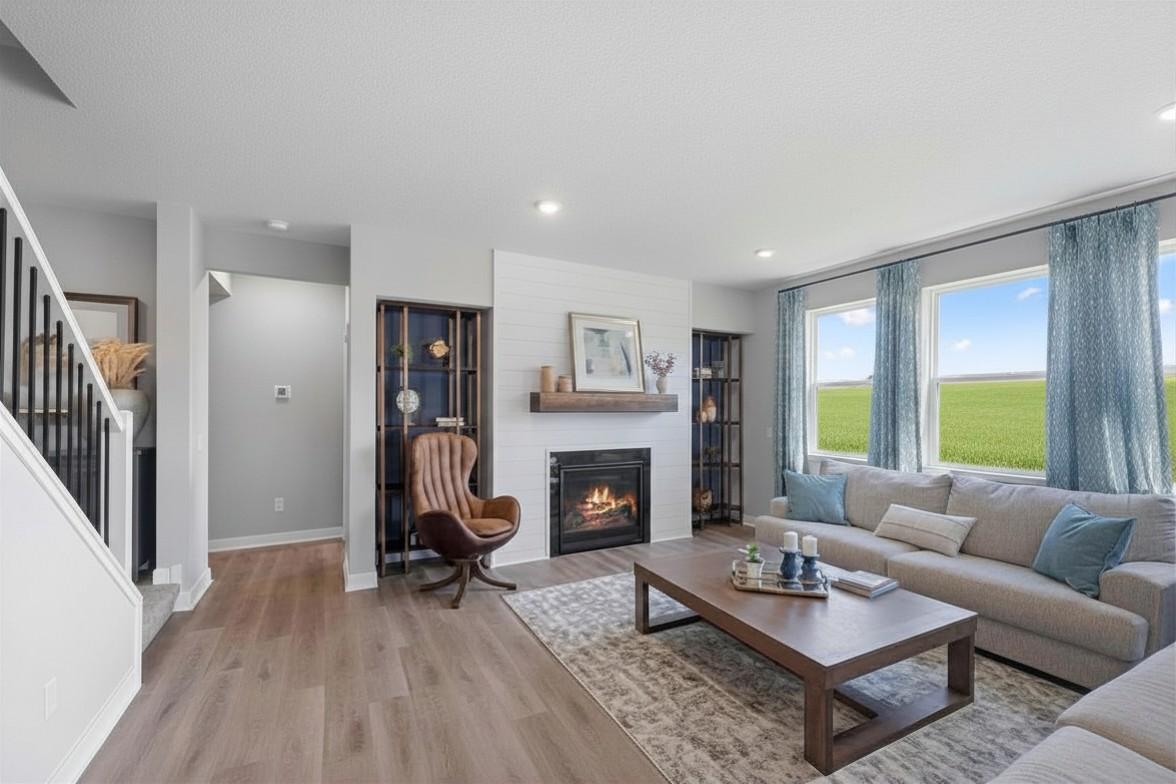 Comfortable family room with large windows, gas fireplace and beautiful built-ins! Model photo, options and colors may vary.
