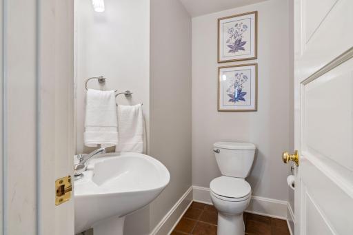 Convenient powder room featuring a classic pedestal sink accessible from the kitchen
