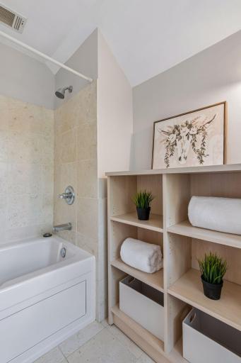 Close-up detail of the tiled shower and custom built-in shelving.