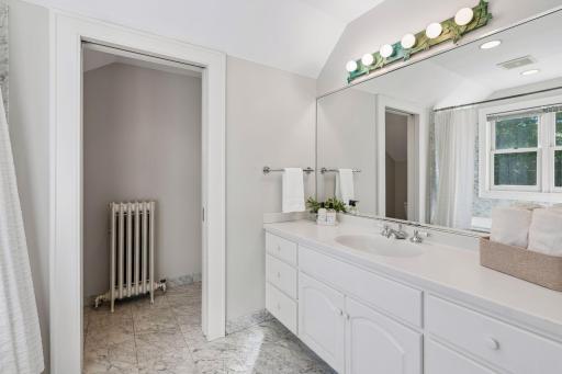 Clean, classic bathroom with a generous vanity and traditional radiator detail.