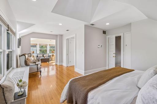 Spacious bedroom with hardwood flooring, generous windows, and a peaceful neutral palette.
