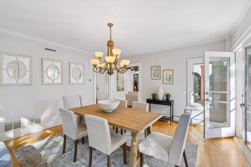 Refined dining room with classic millwork, statement lighting, and views to the outdoor space.