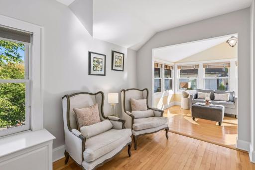 Cozy bedroom sitting area overlooking a bright adjoining space.