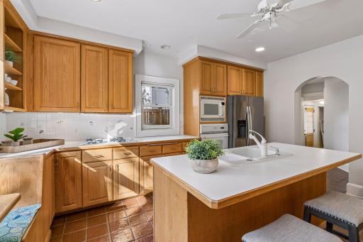 Warm and functional kitchen with wood cabinetry, stone countertops, and a central island.