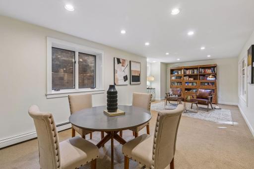 Comfortable lower-level sitting and dining area with built-in bookshelves and flexible gathering space.