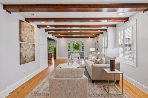 Elegant living space showcasing beamed ceilings, abundant natural light, and classic detailing.