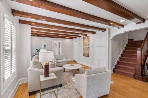 Comfortable sitting area with custom built-ins, warm wood accents, and a graceful staircase.