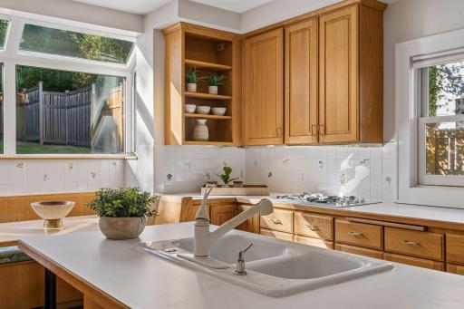 Detailed view of the kitchen’s stone countertops, farmhouse-style sink, and custom wood cabinetry