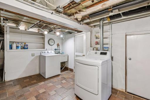 Dedicated laundry area with cabinetry, utility sink, and full-size appliances.