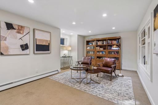 Relaxed lounge with leather seating, a reading area, and extensive built-in shelving.