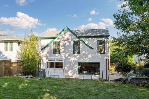 Rear exterior showcasing the home's architecture, landscaped yard, and outdoor living area.