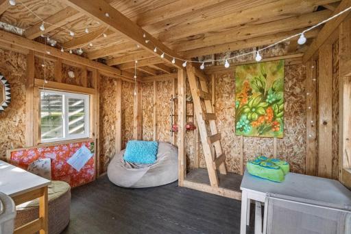 Rustic garden retreat with wood-paneled walls, casual seating, and colorful accents.