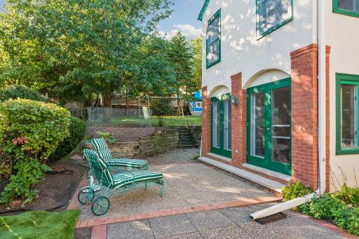 Private brick-paved courtyard tucked alongside the home and surrounded by mature landscaping.