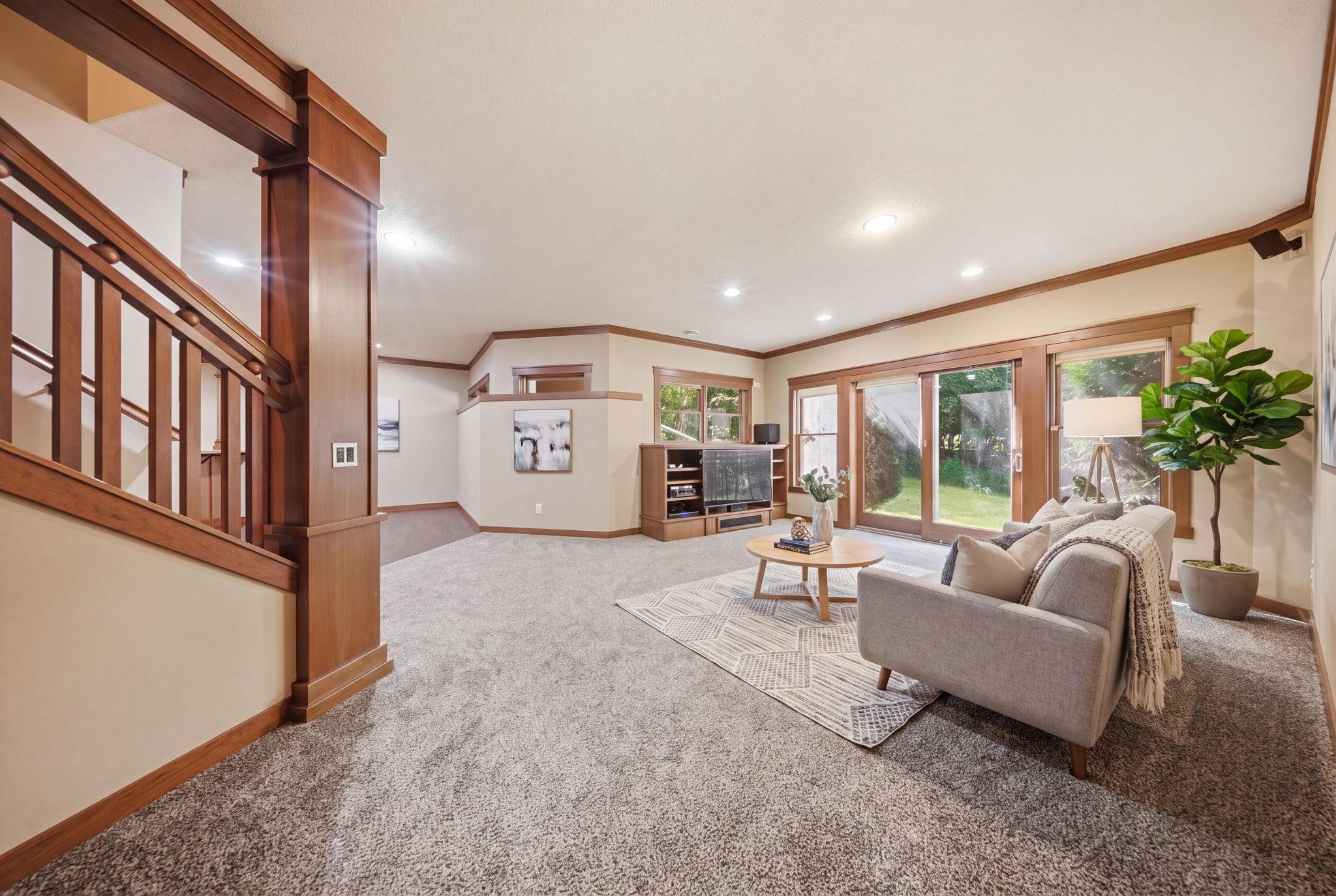 The finished walkout lower level is built for entertaining with a generous family room and a beautifully designed rustic bar showcasing rich wood finishes. (virtually staged)