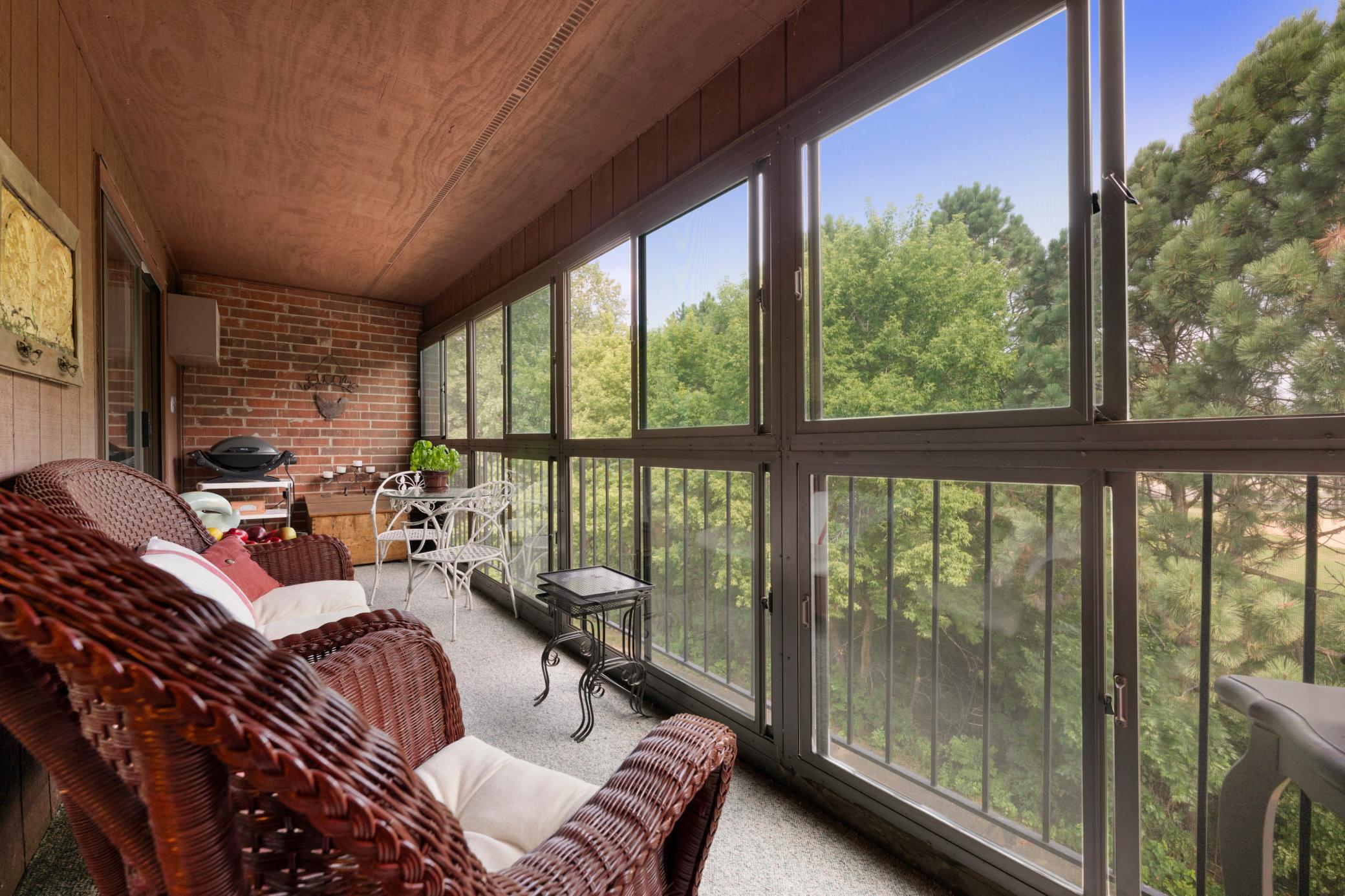 A rare find: a glass-enclosed top-floor screen porch with treetop views and no buildings in sight.