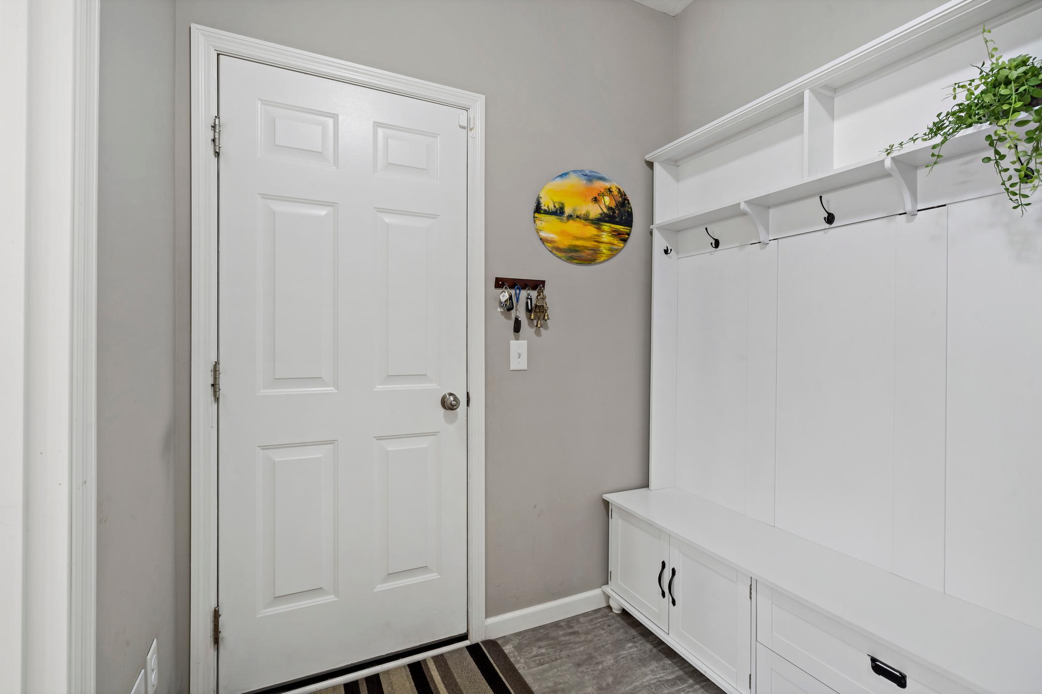 Entrance from the garage is well planned with coat closet, coat hooks, and storage bench.