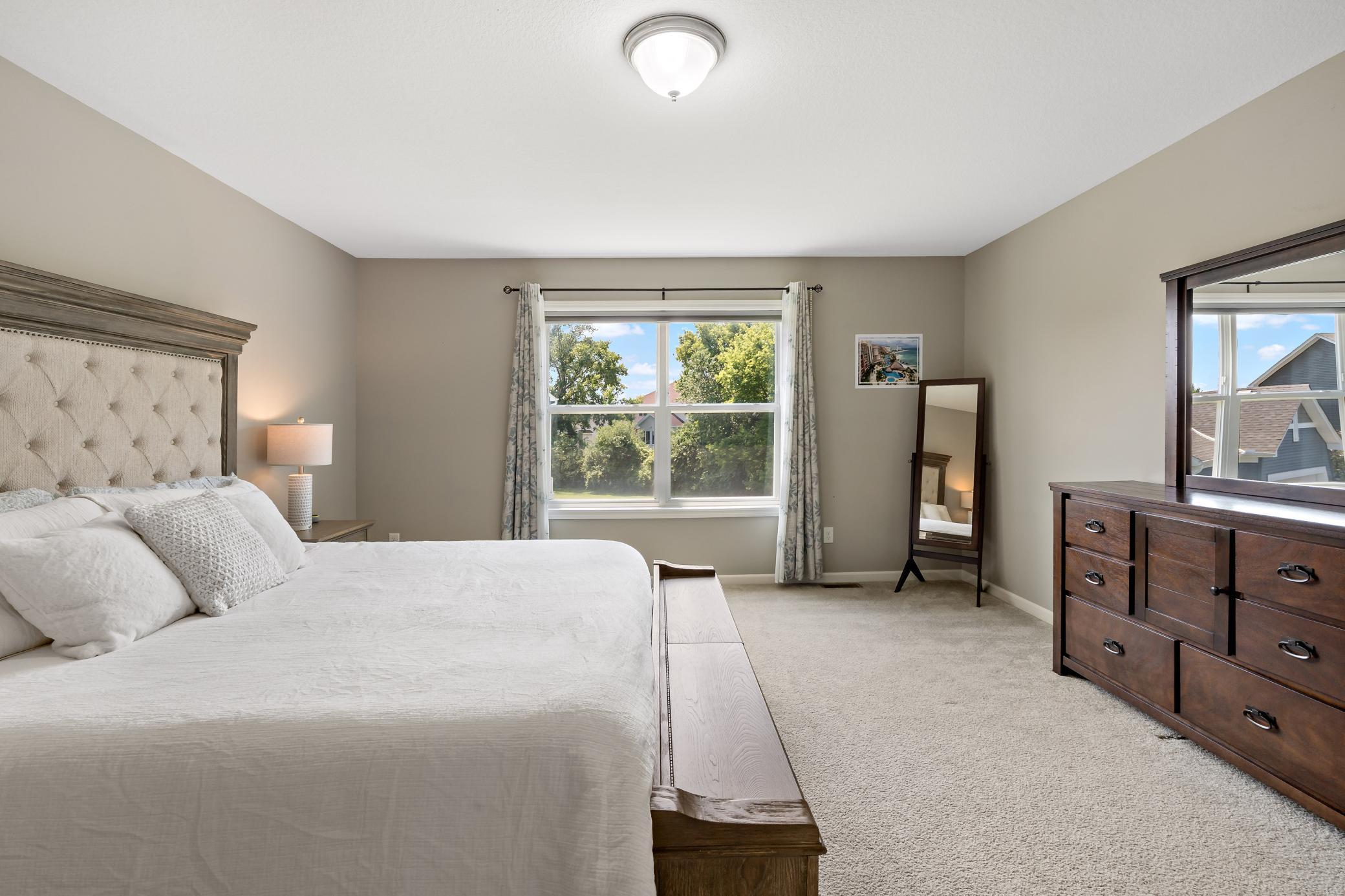 Spacious primary bedroom with views of the back yard.