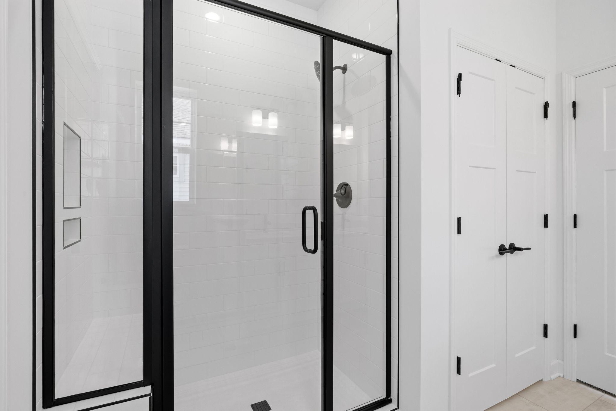 A glass-enclosed shower offers a spa-like experience in the en-suite bathroom