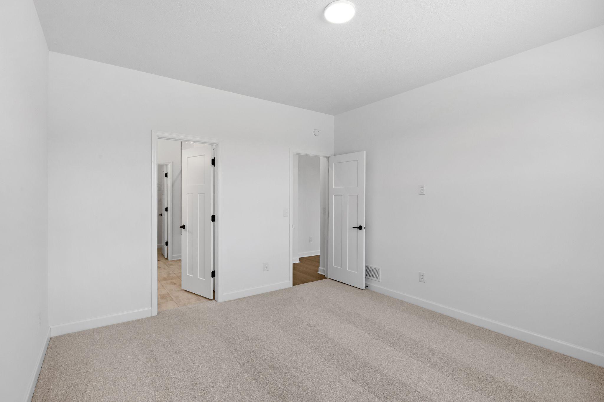 The bedroom features wall-to-wall plush carpeting
