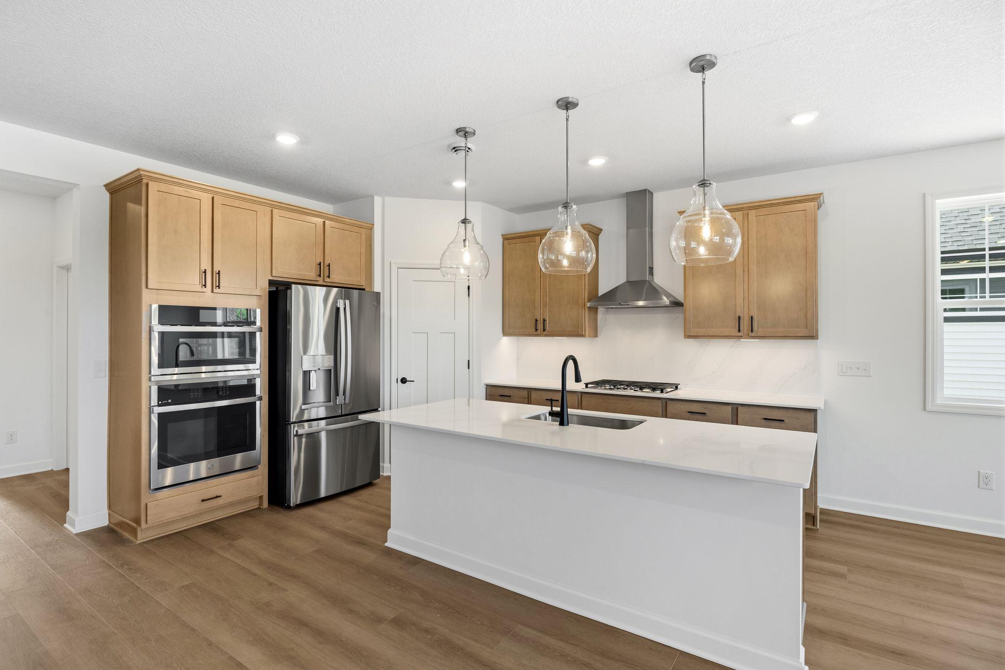 This multifunctional kitchen features a spacious center island that extends out to a breakfast bar, while brand-new appliances and plenty of storage help make food prep simple.