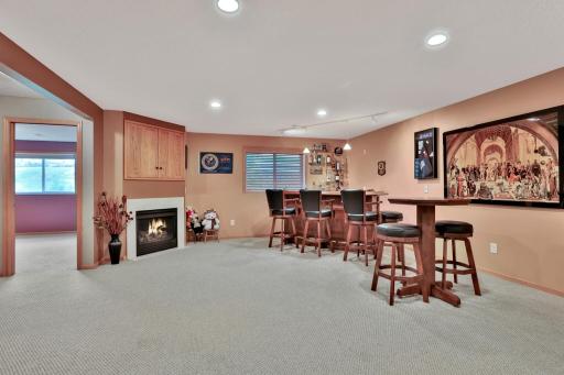 Lower level family room with corner gas fireplace. Bar/High top and chairs/stools (all furniture and not attached) could be purchased but are not included in sale.