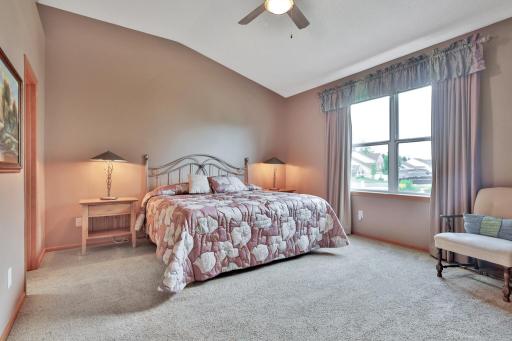 Main floor primary bedroom with vaulted ceiling and fan.
