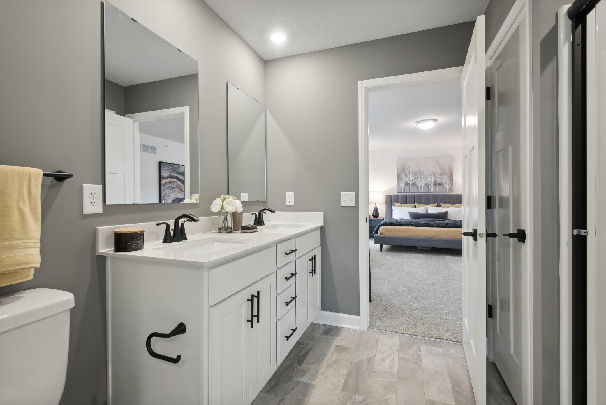 (Photo of a decorated model, actual homes finishes will vary) An extension of the owner's suite, this private and spacious bath contains a double-vanity, a linen closet and a shower.