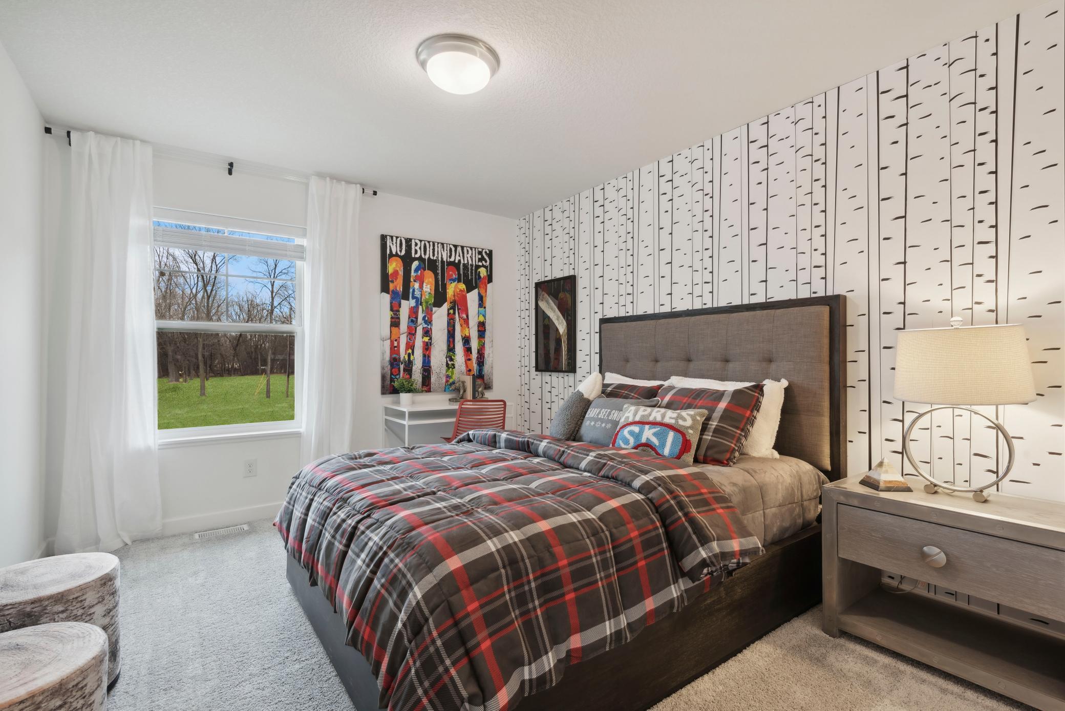 (Photo of a decorated model, actual homes finishes will vary) One of two generously sized upper level secondary bedrooms with spacious closets.