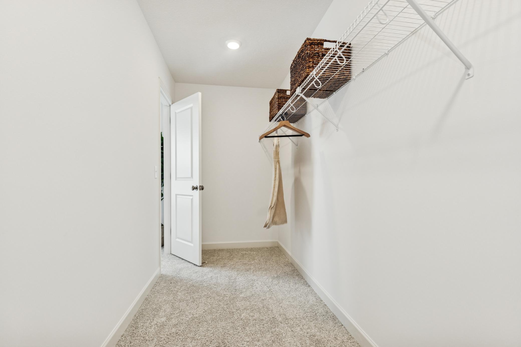 (Photo of model home, features will vary) A large walk-in closet with mesh-wire shelving provides abundant room to store wardrobes, shoes, accessories and much more