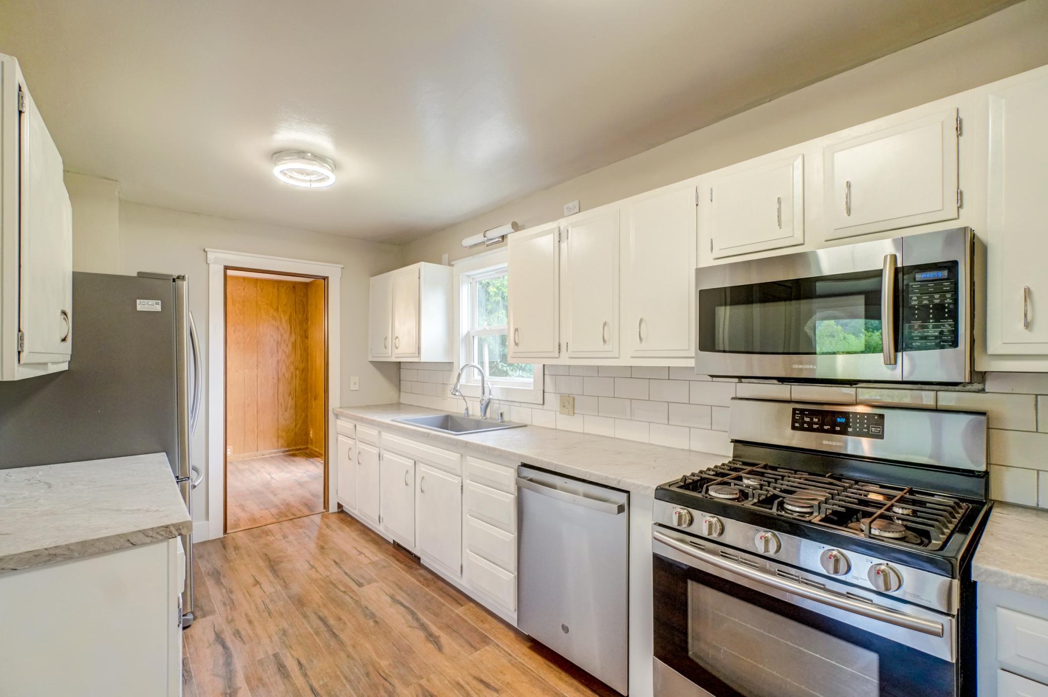 Stylish kitchen with stainless steel appliances, new countertops, and sink.
