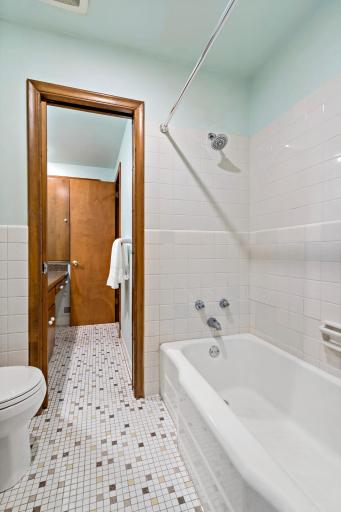 Full bathroom conveniently located between the three additional bedrooms, featuring a separate toilet and bath/shower area from the vanity—ideal for multiple people getting ready at once.