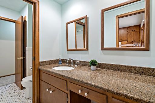 Full bathroom conveniently located between the three additional bedrooms, featuring a separate toilet and bath/shower area from the vanity—ideal for multiple people getting ready at once.