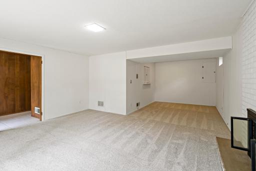 Bright lower-level entertaining space with large windows, a cozy fireplace, and privacy from the main floor—perfect for relaxing or gathering with guests.