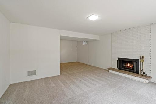 Bright lower-level entertaining space with large windows, a cozy fireplace, and privacy from the main floor—perfect for relaxing or gathering with guests.
