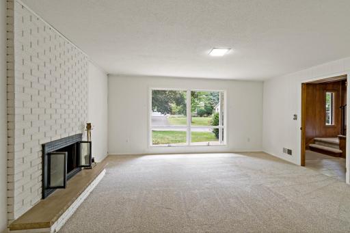 Bright lower-level entertaining space with large windows, a cozy fireplace, and privacy from the main floor—perfect for relaxing or gathering with guests.