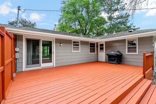 Large, recently stained deck with convenient access from the dining room, offering a wonderful space to relax, entertain, and enjoy the private backyard and surrounding nature.