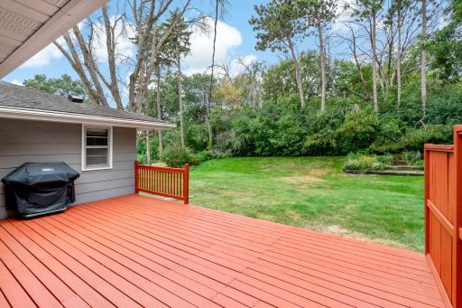 Large, recently stained deck with convenient access from the dining room, offering a wonderful space to relax, entertain, and enjoy the private backyard and surrounding nature.