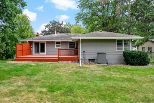 Large, recently stained deck with convenient access from the dining room, offering a wonderful space to relax, entertain, and enjoy the private backyard and surrounding nature.