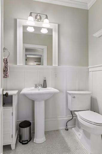 The full ceramic tile bath has been remodeled and features a mini hex tile floor, pedestal sink, and subway tile tub/shower surround.
